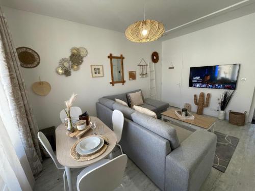 a living room with a couch and a table at Le Bohème - Centre Ville, Netflix et WIFI, parking, idéal familles, couples et voyages d'affaire in Niort