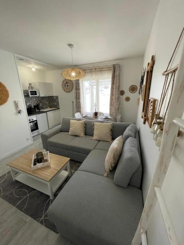 un salon avec un canapé et une table dans l'établissement Le Bohème - Centre Ville, Netflix et WIFI, parking, idéal familles, couples et voyages d'affaire, à Niort
