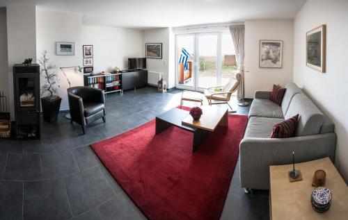 ein Wohnzimmer mit einem Sofa und einem roten Teppich in der Unterkunft Ferienwohnung Aalfänger in Breege