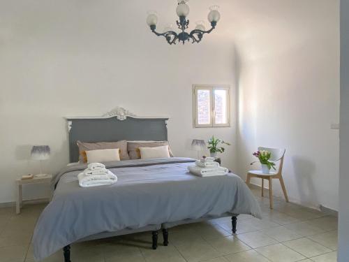 een slaapkamer met een blauw bed en een kroonluchter bij Catania Bedda Home in Catania