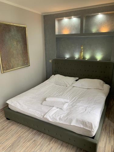 a bed with white sheets and pillows in a room at Baltic Park Apartament in Świnoujście