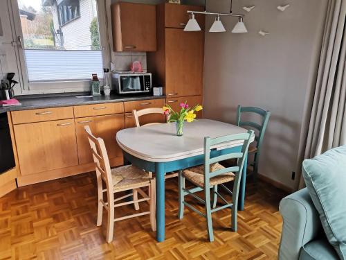 a kitchen with a table with chairs and a microwave at Haus am Hennesee in Meschede