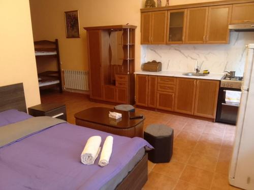 una camera con letto e una cucina con armadi in legno di Arm Hotel a Yerevan