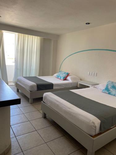 Habitación de hotel con 2 camas y ventana en Luna Creciente en Santa Cruz - Huatulco
