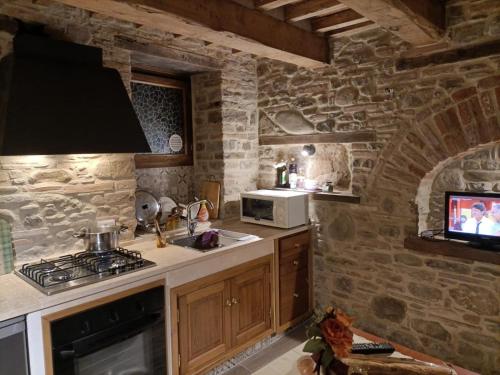 a kitchen with a stone wall with a stove top oven at La Terrazza camere Sansepolcro in Sansepolcro