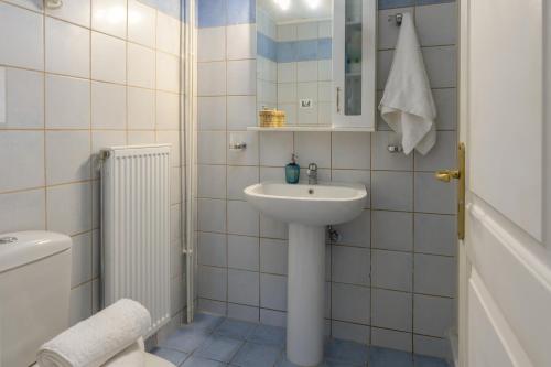 La salle de bains blanche est pourvue d'un lavabo et de toilettes. dans l'établissement Vivian's Studio Endless View, à Svoronata