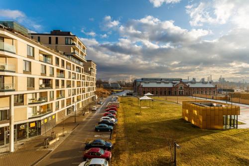 a row of cars parked in a parking lot next to a building at Golden Apartments Rezidence Nová Karolina II. in Ostrava