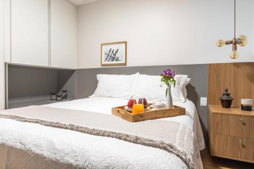 a bedroom with a bed with a tray with flowers on it at CASA CAJU in Aracaju