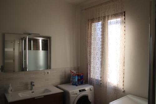 a bathroom with a washing machine and a sink and a mirror at La Terrazza camere Sansepolcro in Sansepolcro