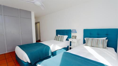 ヴィラモウラにあるPalmeiras do Golfe 160 - Clever Detailsの青と白の部屋のベッド2台