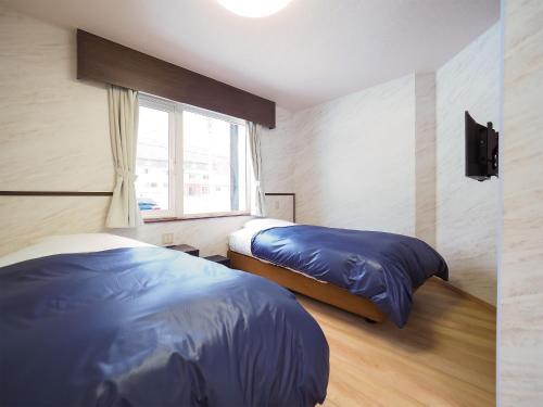 מיטה או מיטות בחדר ב-Petit Hotel Gracey Tomamu
