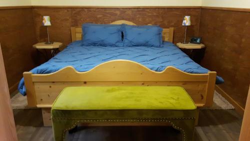 a bedroom with a wooden bed with a green stool at Tschurtschenthaler Rentals in Golden