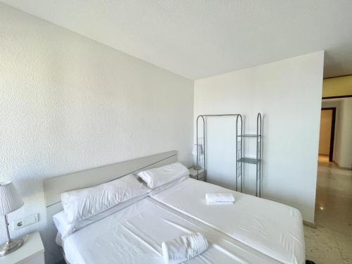 - une chambre blanche dotée d'un lit avec des draps et des oreillers blancs dans l'établissement TORRE VALENCIA LEVANTE BEACH, à Benidorm