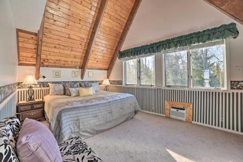 a bedroom with a bed and two windows at Dreamy Lake Skegemog Retreat Boat, Ski and Sip! in Williamsburg