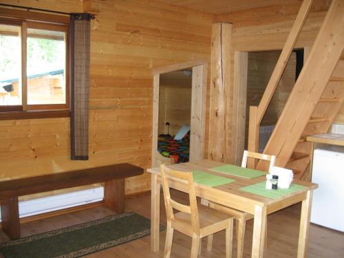 a dining room in a log cabin with a table and chairs at Tschurtschenthaler Rentals in Golden
