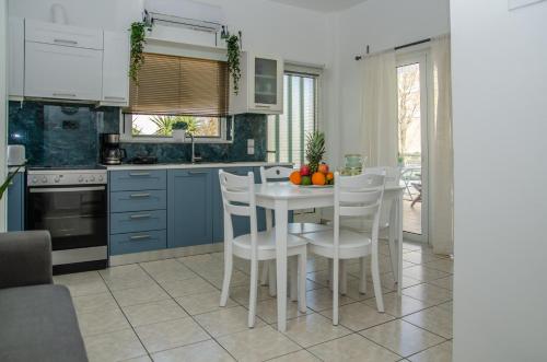 a kitchen with a white table and white chairs at Cozy Home (close to the beach) in Nea Kydonia