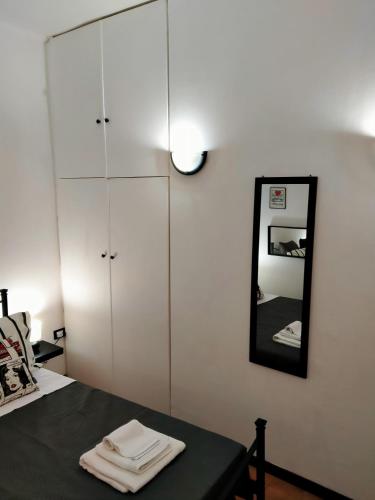a bedroom with a bed with a mirror and white cabinets at La Tegola in Tivoli
