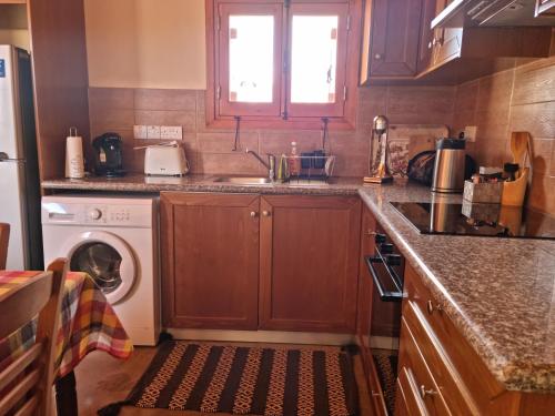 cocina con fregadero y lavadora en Fontana Traditional House, en Anarita