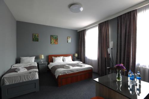Habitación de hotel con 2 camas y mesa en Hotel Evita Tashkent en Tashkent