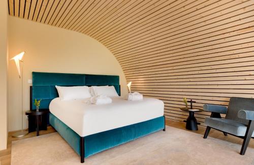a bedroom with a large bed and a wooden wall at Souki ~ Lodges & Spa in Cabrières