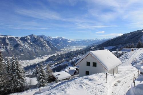 a house covered in snow on top of a mountain at Moderne 3-Zimmerwohnung, an Skipiste, mit Aussicht in Flumserberg