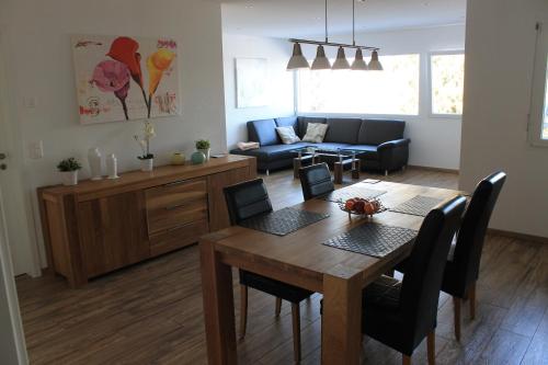 a dining room and living room with a table and chairs at Moderne 3-Zimmerwohnung, an Skipiste, mit Aussicht in Flumserberg