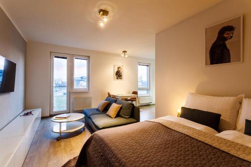 a bedroom with a bed and a couch at Golden Apartments Rezidence Nová Karolina II. in Ostrava