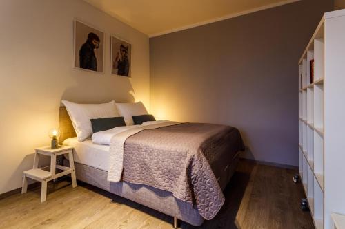 a bedroom with a bed and a side table at Golden Apartments Rezidence Nová Karolina II. in Ostrava