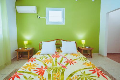 sypialnia z łóżkiem z kolorową narzutą w obiekcie Villa Z'EPICES-MARINA C0NCIERGERIE w mieście Saint-François
