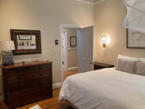 a bedroom with a bed and a dresser and a mirror at 3 Queen Street in Calitzdorp