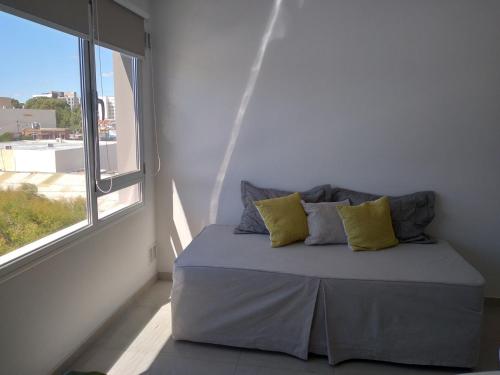 a bed in a room with a large window at Departamento Marea III Puerto Madryn in Puerto Madryn