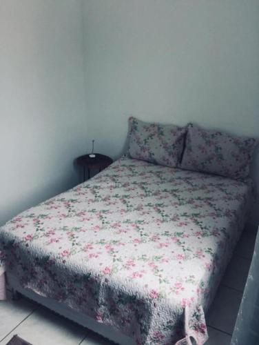 a bedroom with a bed with a floral comforter at Apartamento 403 Bloco I - Condomínio dos lagos II in Capitólio