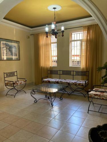 Sala de estar con 2 bancos y mesa en Hotel Plaza CA, en Mérida