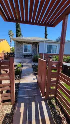 a wooden pergola in front of a house at Adorable modern guesthouse with full kitchen in Encino