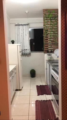 uma cozinha com um frigorífico branco e uma janela em Apartamento 403 Bloco I - Condomínio dos lagos II em Capitólio