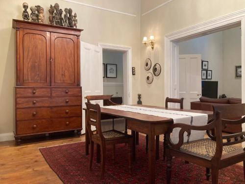 a dining room with a table and chairs and a dresser at 3 Queen Street in Calitzdorp