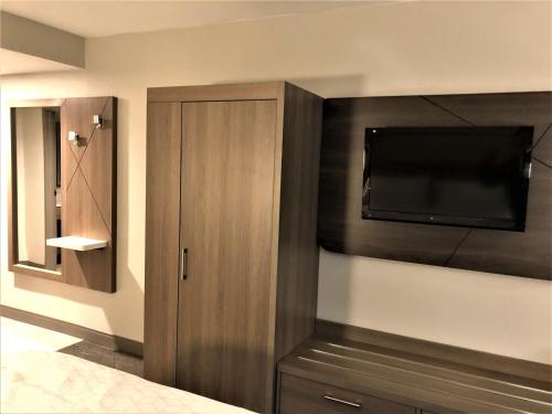 a bedroom with a flat screen tv on a wall at Holiday Inn Express & Suites Donegal by IHG in Donegal