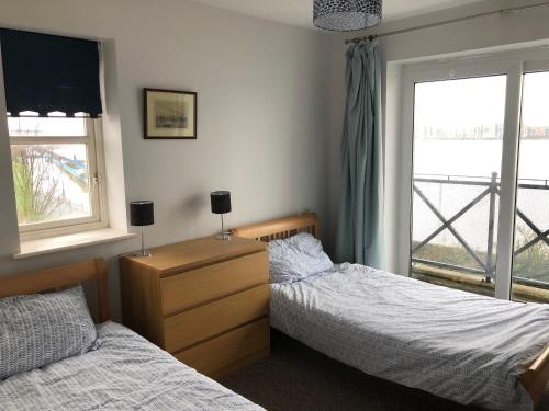 a bedroom with two twin beds and a window at Thames View & free parking - perfect long stay workers only in London