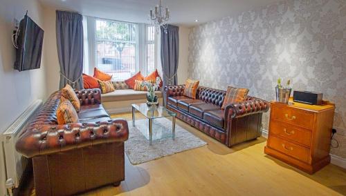 a living room with leather couches and a table at Scarborough Stays - Luxury Townhouse Ideal for large groups - HOT TUB in Scarborough