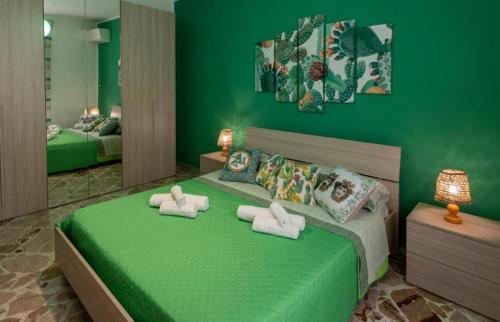 a green bedroom with two towels on a bed at La terra dei sogni in Marsala