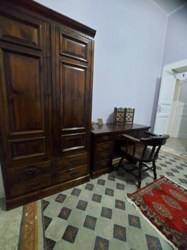 Habitación con escritorio y armario grande de madera. en B&b Cabral, en Messina