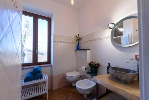 bagno con lavandino, servizi igienici e specchio di Cascina Fogona - Sport e Natura ad Altare