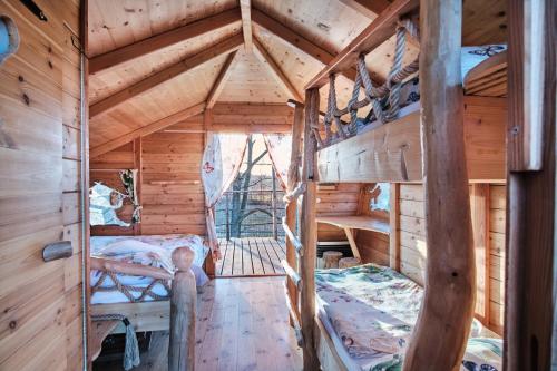 ein Schlafzimmer in einem Blockhaus mit einem Bett darin in der Unterkunft Treehouse Křemílek in Jesenice