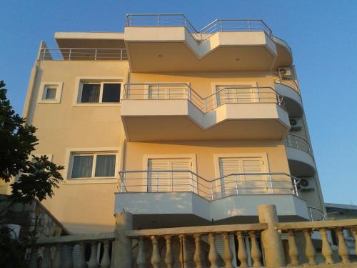 a building with balconies on the side of it at Magic Ionian Apartments & Rooms in Himare