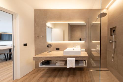 ein Bad mit einem Waschbecken und einem Spiegel in der Unterkunft Weingut Gasshof in Appiano sulla Strada del Vino
