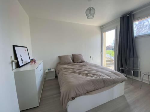 #Casafouilloy Appartement de plein pied avec grande terrasse في Fouilloy: غرفة نوم بيضاء بها سرير ونافذة