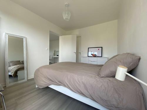 a white bedroom with a bed and a mirror at #Casafouilloy Appartement de plein pied avec grande terrasse in Fouilloy