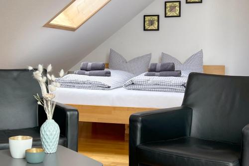 a bedroom with a bed with two chairs and a table at Apartment mit Dachterrasse & Sauna in Wangen im Allgäu