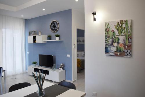 a living room with a tv and a blue wall at White Wall luxury rooms Scala dei turchi in Realmonte