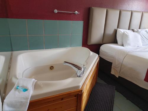 a bathroom with a sink and a bed at Hotel Pigeon Forge in Pigeon Forge
